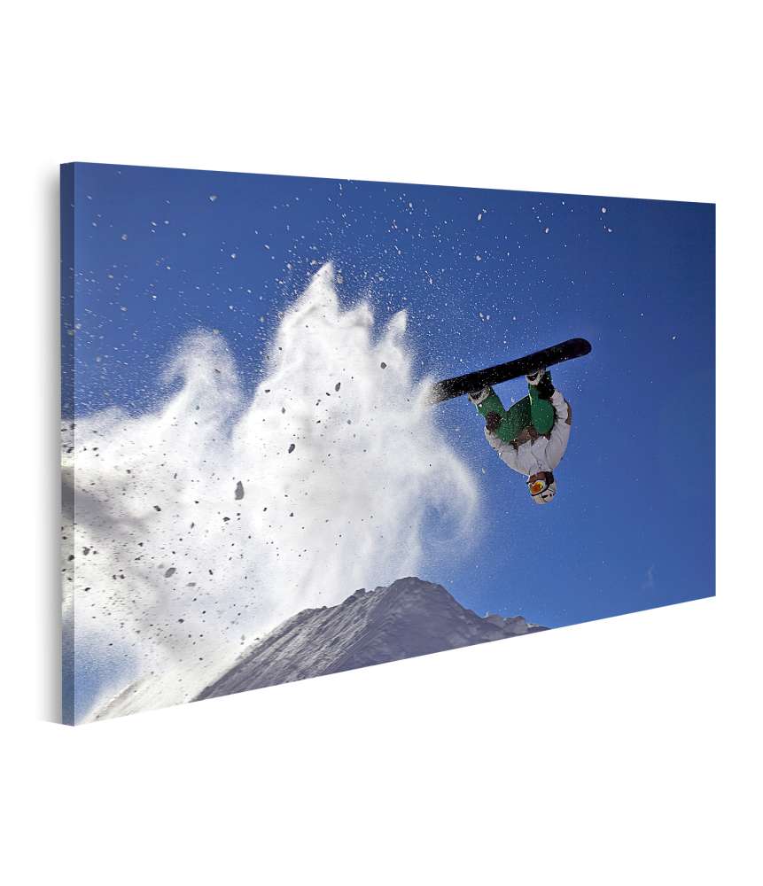 Bild auf Leinwand Snowboarder beim spektakulären Sprung im verschneiten Gebirge