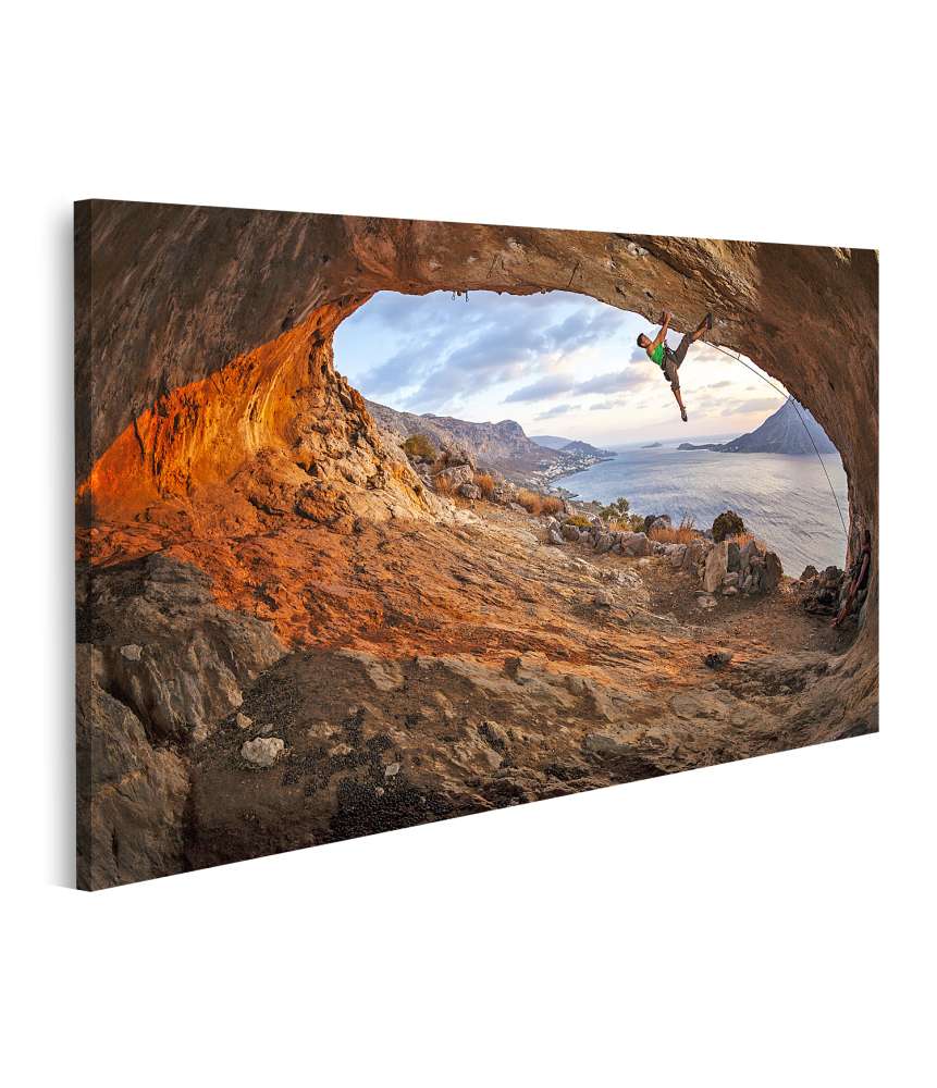 Islandburner Bild auf Leinwand Mann klettert auf dem Dach einer Höhle während des Sonnenuntergangs