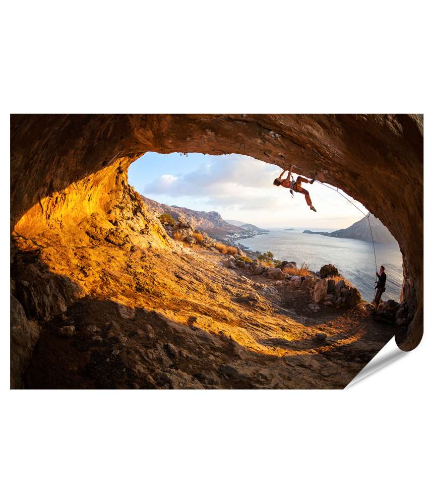 Islandburner XXL Premium Poster Junge Frau klettert in Höhle mit atemberaubender Aussicht im Hintergrund